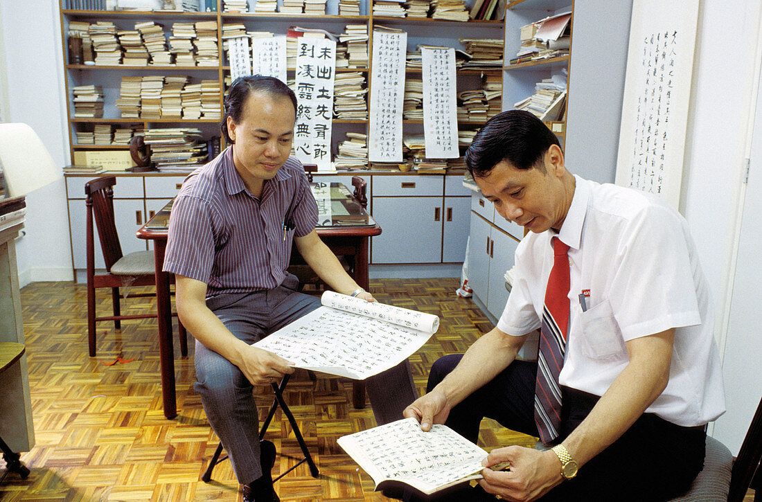 Chinese calligraphers at work in their studio. Macau, China