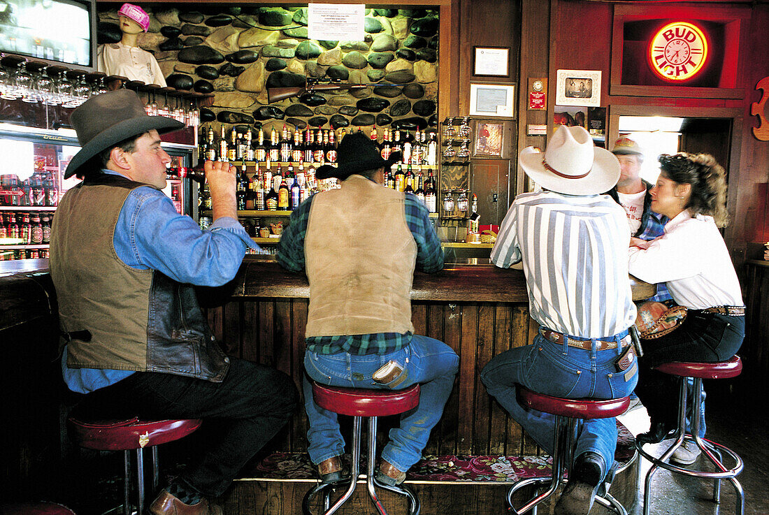 Cowboys drinking at bar of Hotel Irma, named for Buffalo Bill s daughter. Wyoming. USA