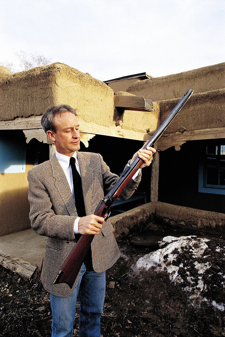 Curator of local museum holding scout Christopher Kit Carson s last gun. Taos, New Mexico. USA