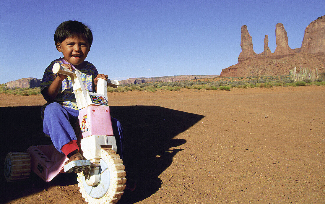 Navajo child and Three Sisters peak. Monument Valley. Utah. USA