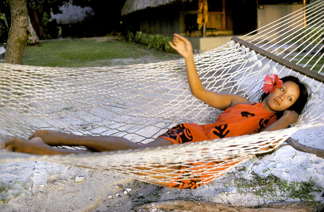 Local Woman ( vahine ) relaxing on a hammock. Bora Bora, Leeward Islands. French Polynesia