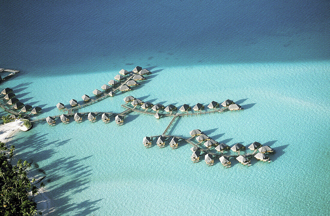 Aerial of luxury hotel huts built on piles on the lagoon. Bora Bora. Leeward Islands. French Polynesia