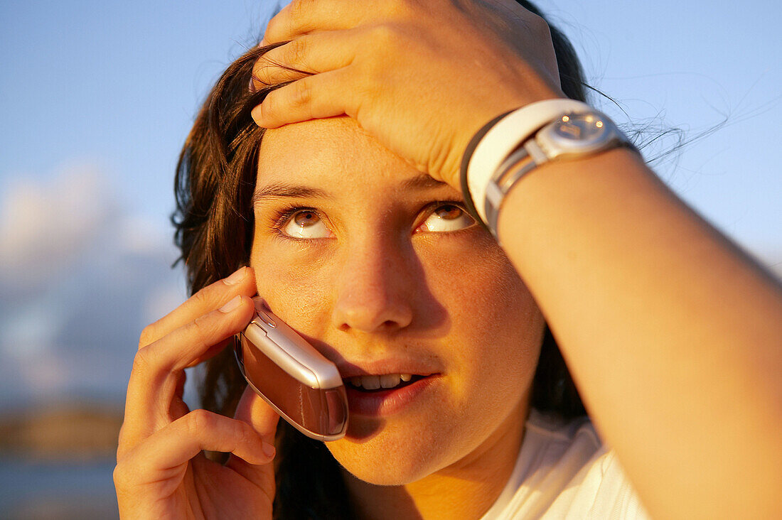 16-jähriger Jugendlicher spricht mit einem Mobiltelefon. Strand von Hendaye. Aquitanien. Frankreich.