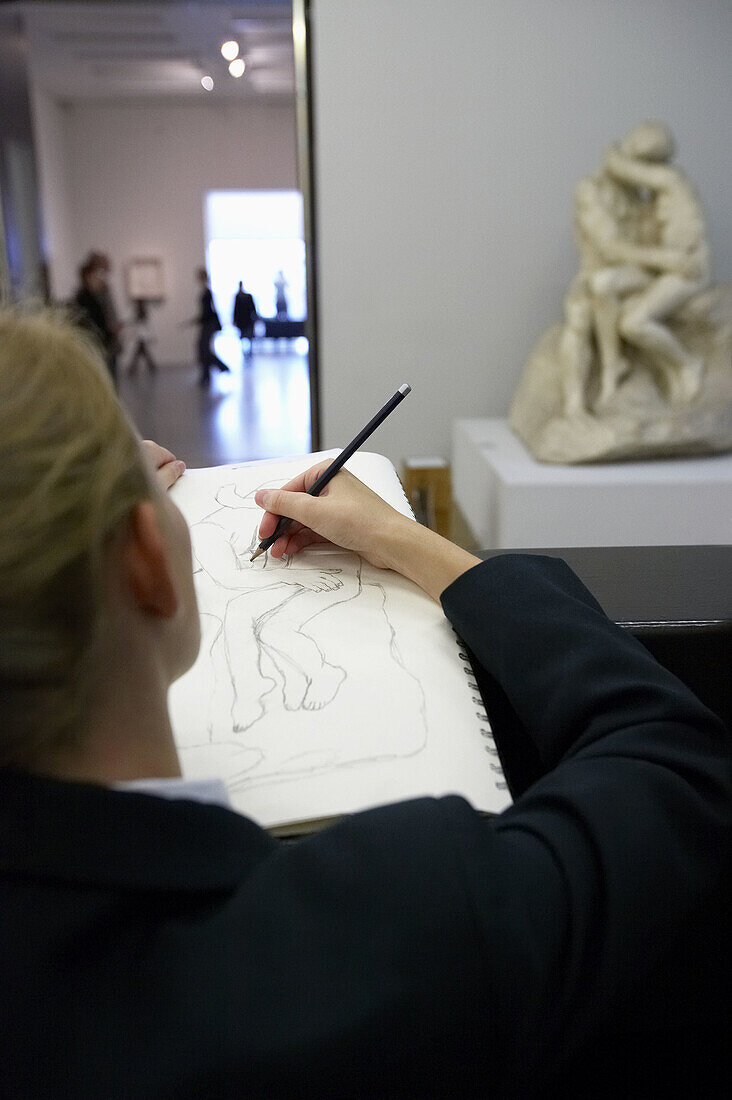 Young woman drawing The Kiss, by Auguste Rodin, Tate Modern. London. England. UK.