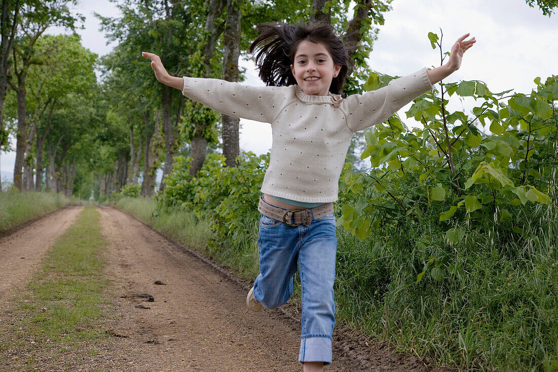 Girl running by tree-lined path. Arkaute, Alava, Euskadi, Spain