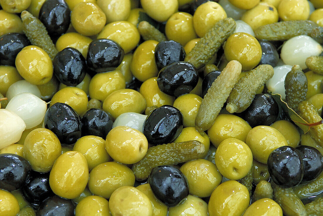 Green and black olives, gherkins and onions with bay leaves.
