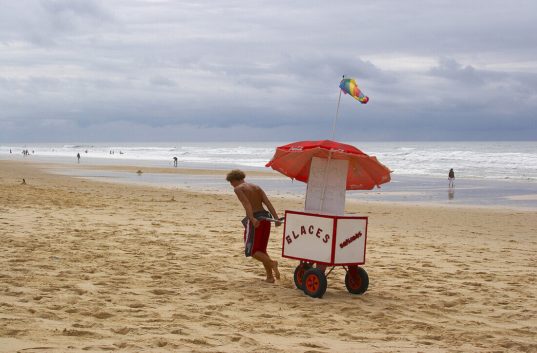 Young man selling ice-cream at the beach of Carcans Plage, dept Gironde, France, Europe