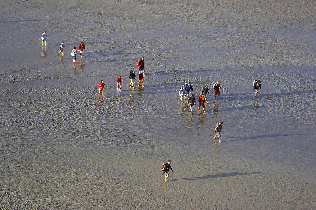 Wanderers at low tide at the Mont St-Michel, Baie du Mont St-Michel, Normandie, dept Manche, France, Europe