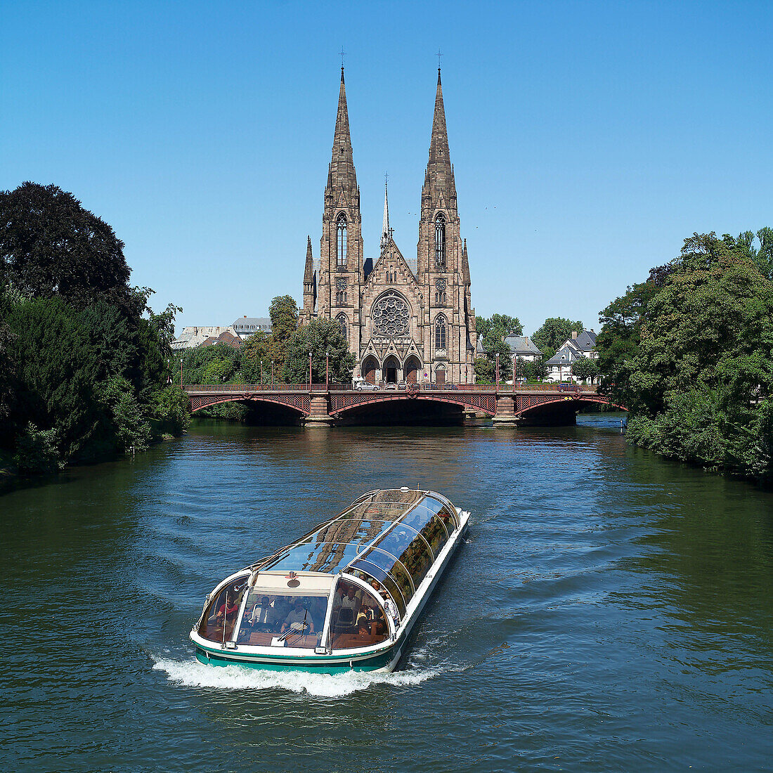 Sightseeing boat and St. Paul church in background. Strasbourg. France