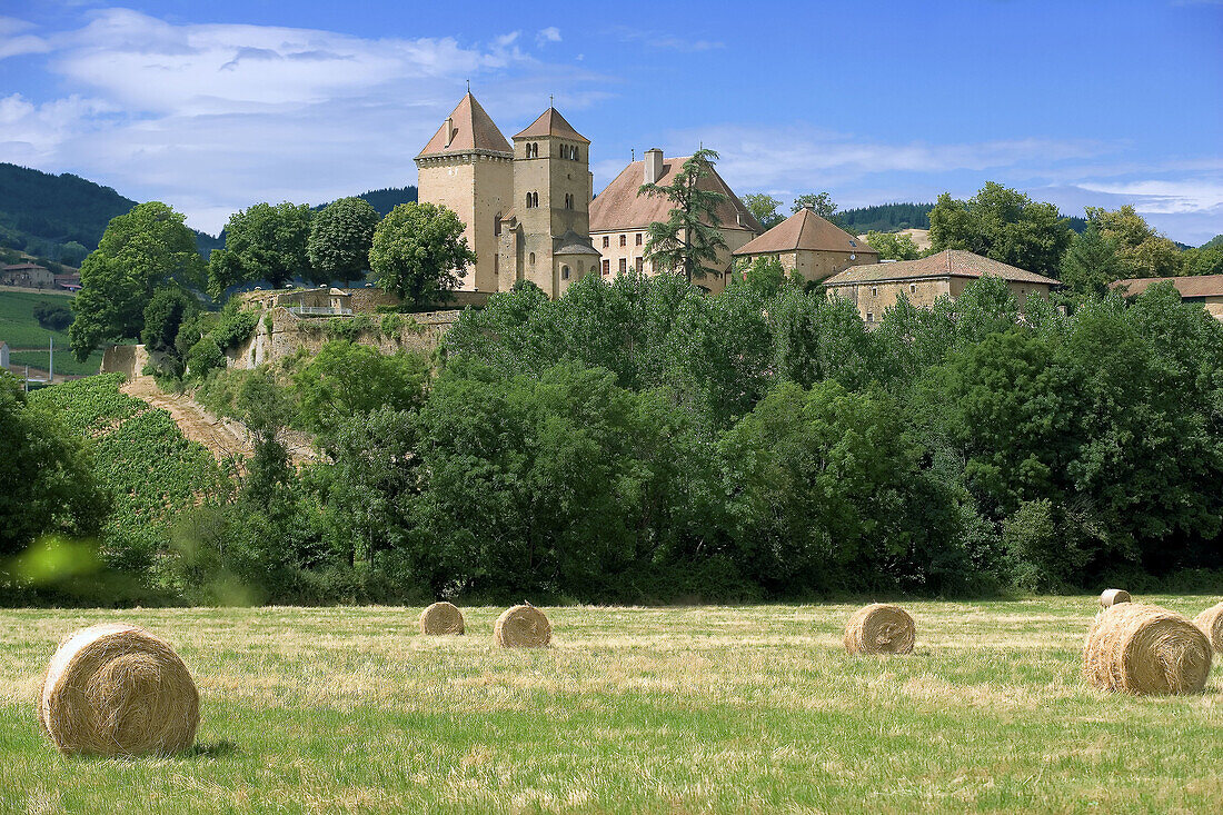 Hay bales and Pierreclos castle XIVth century. Mâconnais. Wine country. Burgundy. France.