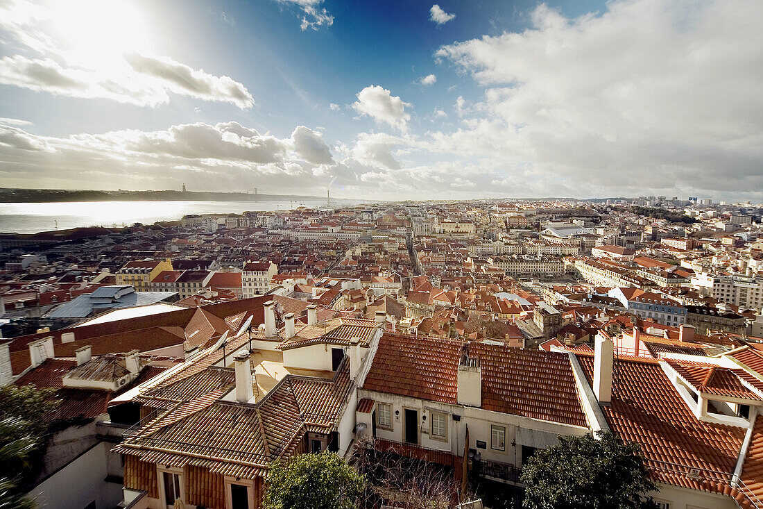 Lisbon, Portugal: Alfama district as seen from Castelo de Sao Jorge (St. George s Castle). In background is the Tagus River and the 25th of April Bridge (Ponte do 25 de Abril).