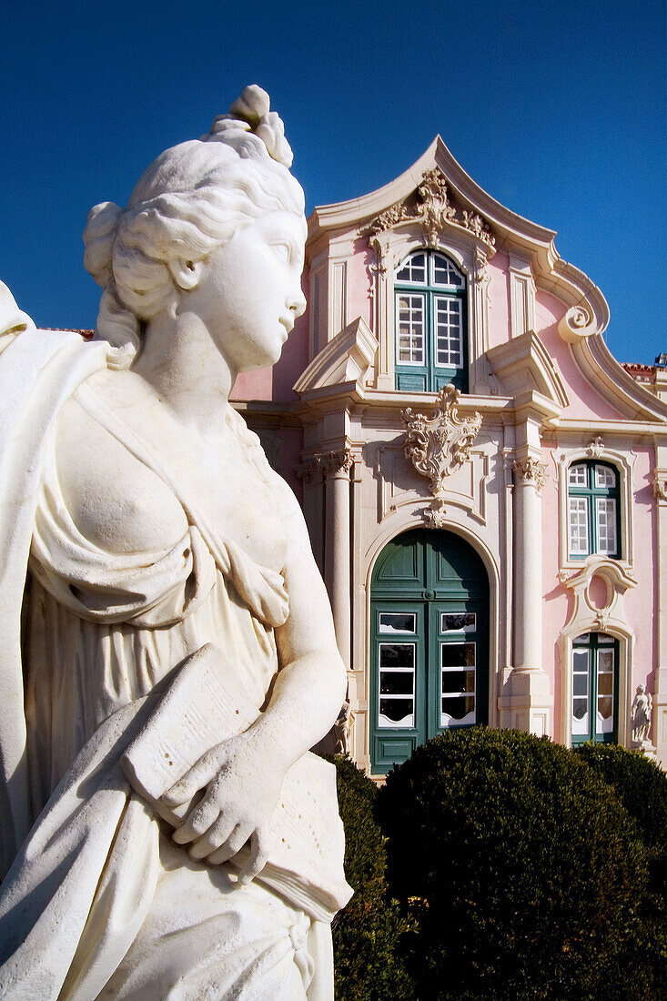 Queluz, Portugal: Classical female figure in the French-style formal gardens of the Palacio Nacional de Queluz. The Queluz Palace, an example of the rococo in Portugal, was constructed between 1747 and 1787. Note Palace in background.