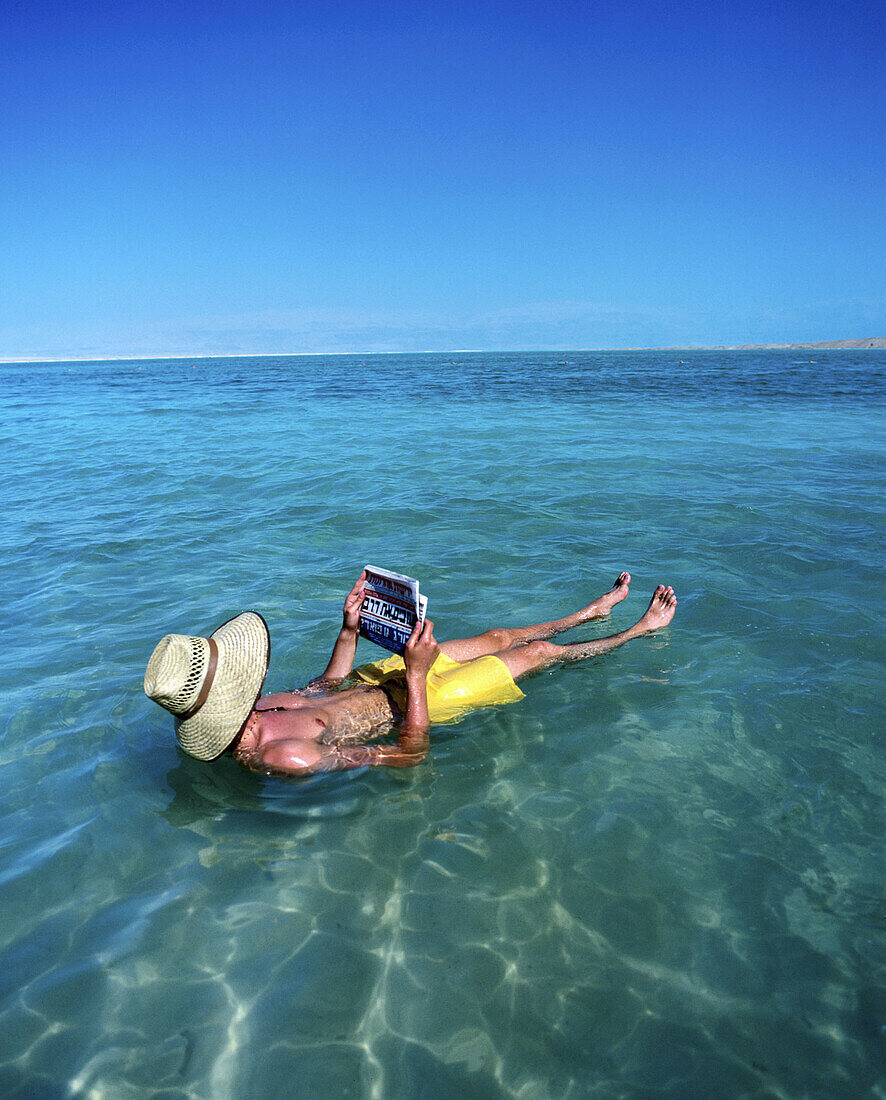 Man reading at Dead Sea. Israel