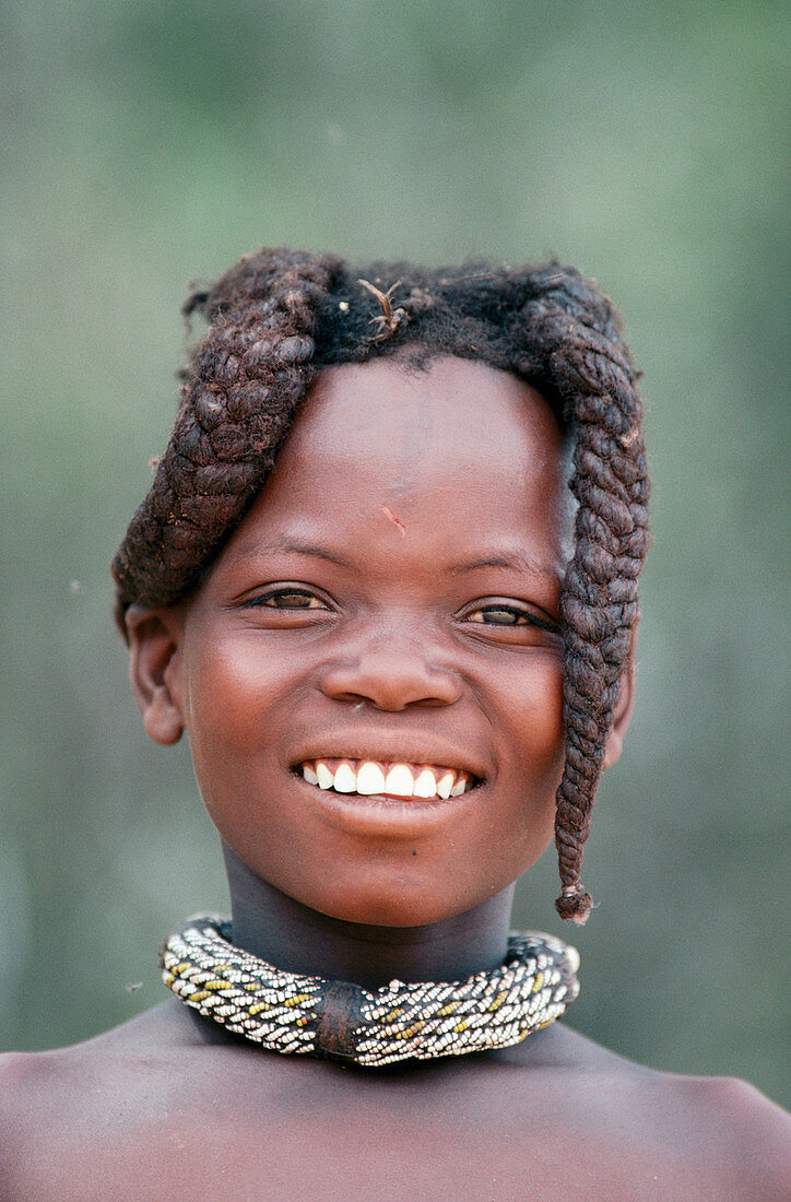 Himba girl with the typicl double plait hairstyle of the pre-adolescent girls. Kaokoland. Namibia
