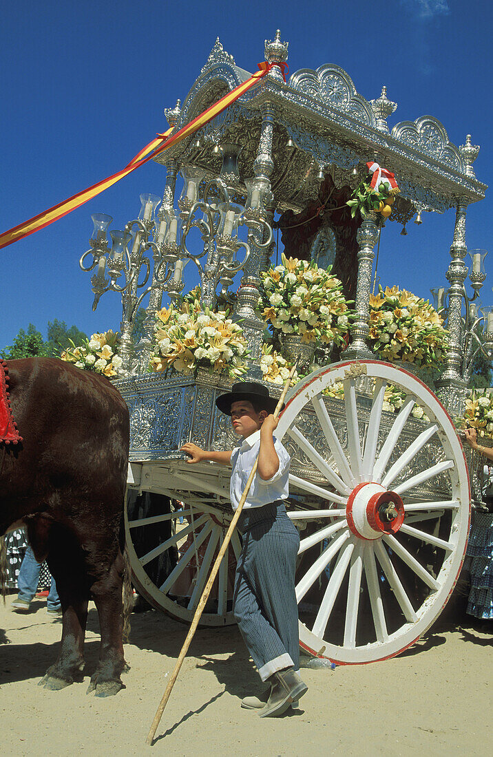 Dressed up boy and beautifully decorated carriage during a famous Pentecost pilgrimage, when the village of El Rocío converts into a colourful spectacle. Province of Huelva, Andalucía, Spain.