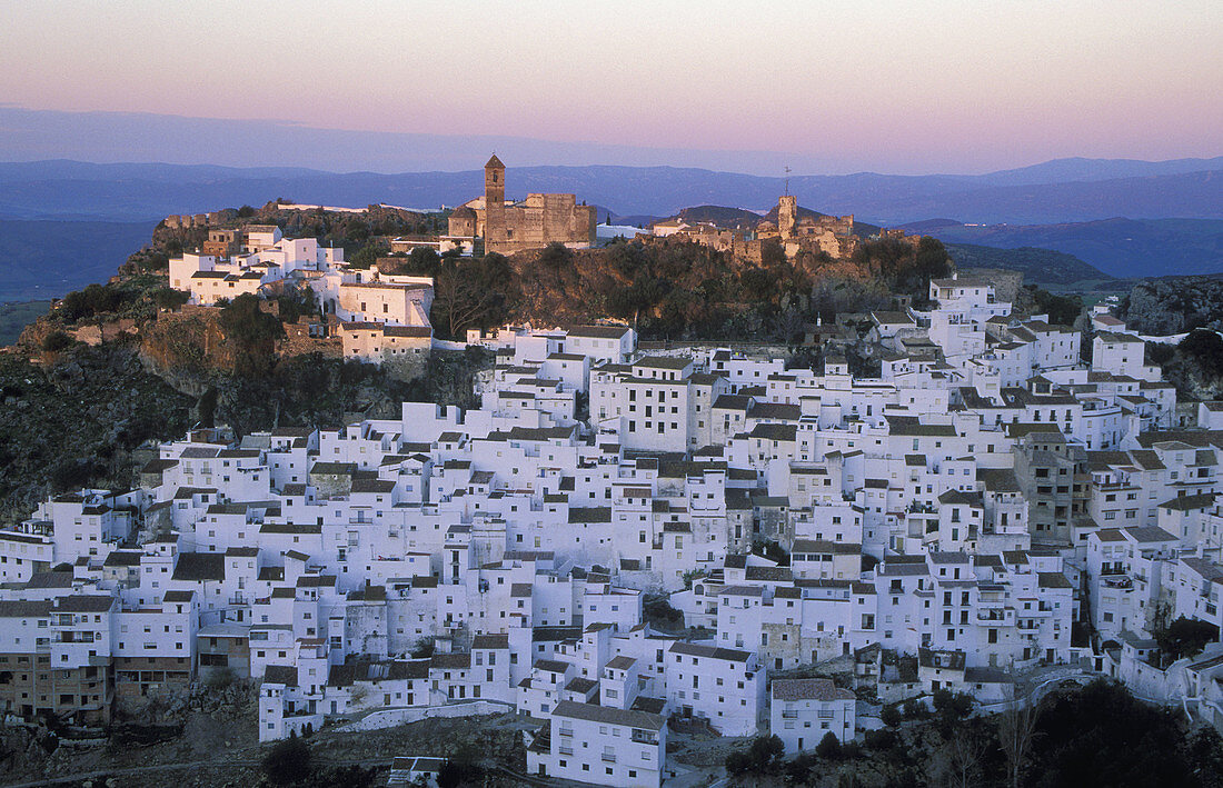 The brilliant White Town of Casares, spectacularly clinging to a steep hillside; at dawn. Province of Málaga, Andalucía, Spain.