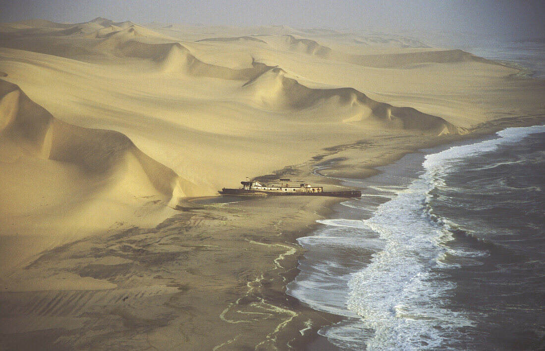 Aerial view of the Shaunee wreck, stranded in 1976 south of Walvis Bay, between Namib Desert and Atlantic Ocean. Namib-Naukluft Park, Namibia.