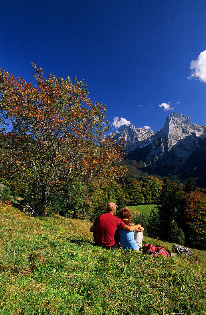 Couple resting on alpine pasture, Kaiser range in background, Wilder Kaiser range, Tyrol, Austria