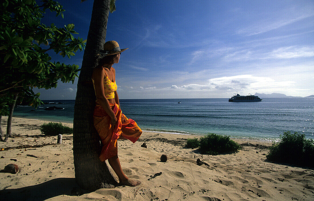 Woman on a sandy beach looking out to sea, Navadra Island, Mamanuca group, Fiji, South Sea
