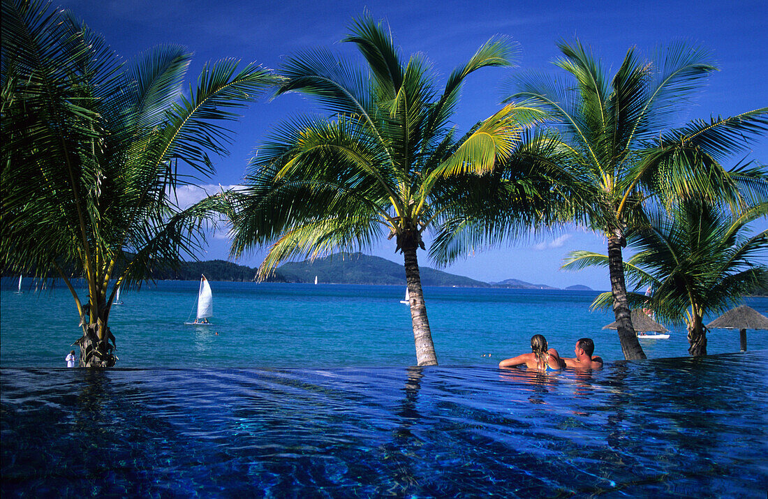 Ein Paar im Pool des luxuriösen Beach Club Resorts auf Hamilton Island, Whitsunday Islands, Great Barrier Reef, Australien