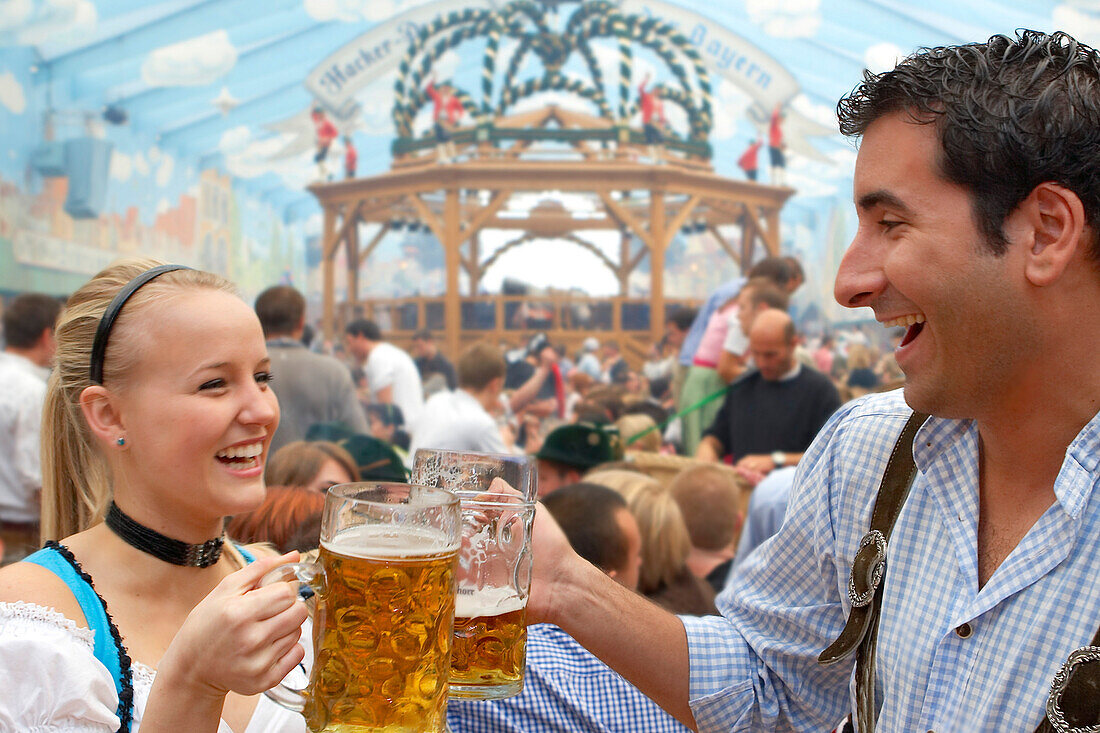 Junges Paar trinkt Bier auf dem Oktoberfest, München, Bayern, Deutschland