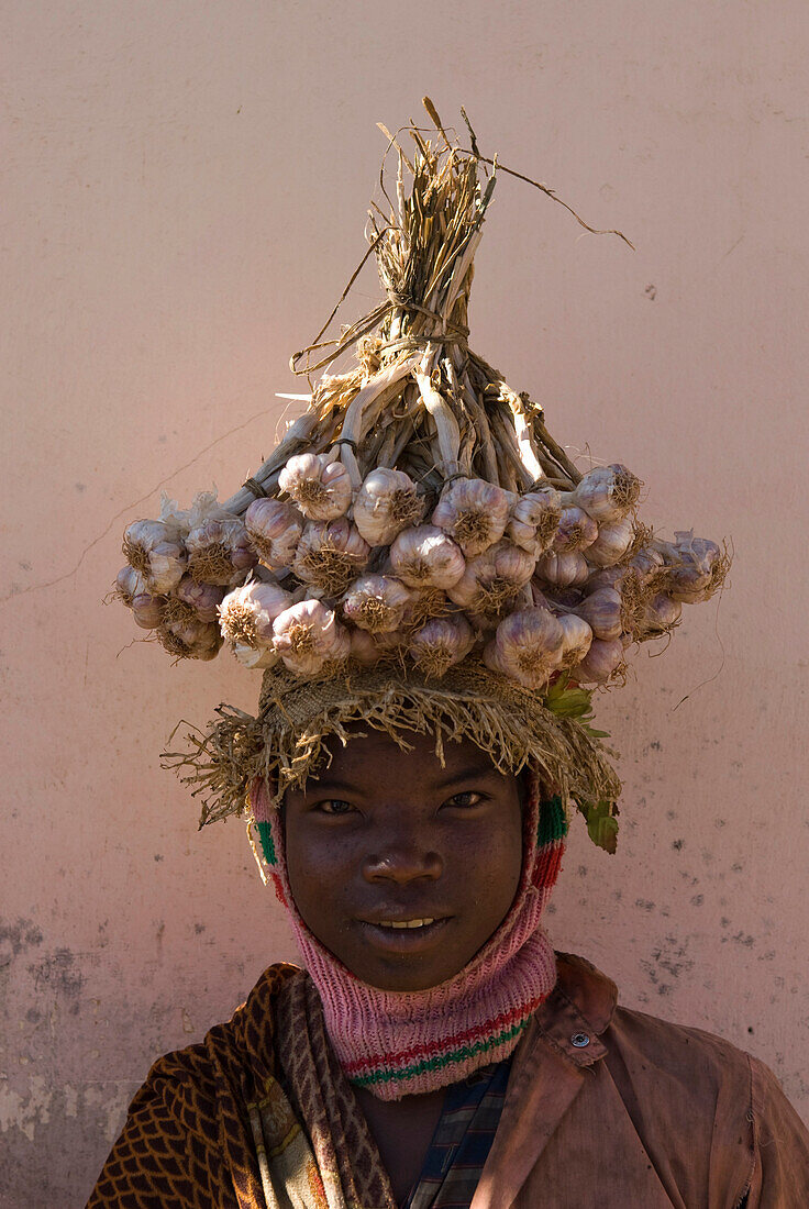 Mann trägt Knoblauch am Kopf, Madagaskar, Afrika