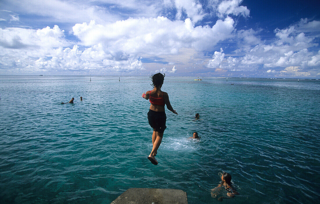 Children jumping into the water at Point Venus, Tahiti, French Polynesia, south sea