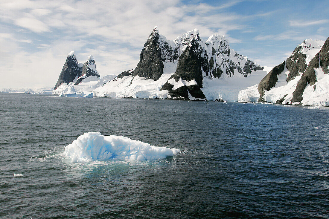 Reflections and snow covered mountains in Lemaire Channel in Antarctica.