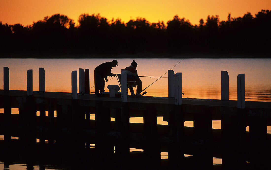 Fishermen on the jetty at sunset, Lakes Entrance, Victoria, Australia