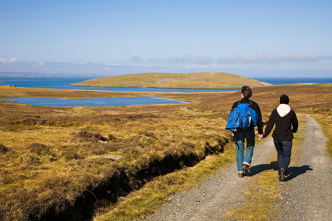 Eine Frau und ein Mann, ein Paar wandern Hand in Hand, Insel Bressay vor Lerwick, Shetland, Schottland, Großbritannien, England, MR