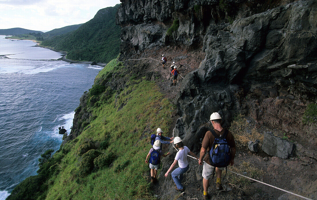 People hiking on Lower Road, an exposed section at the beginning of the climb to Mt. Gower, Lord Howe Island, Australia
