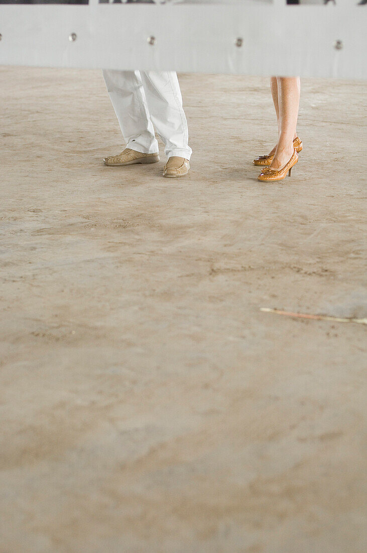 Couple standing behind a billboard