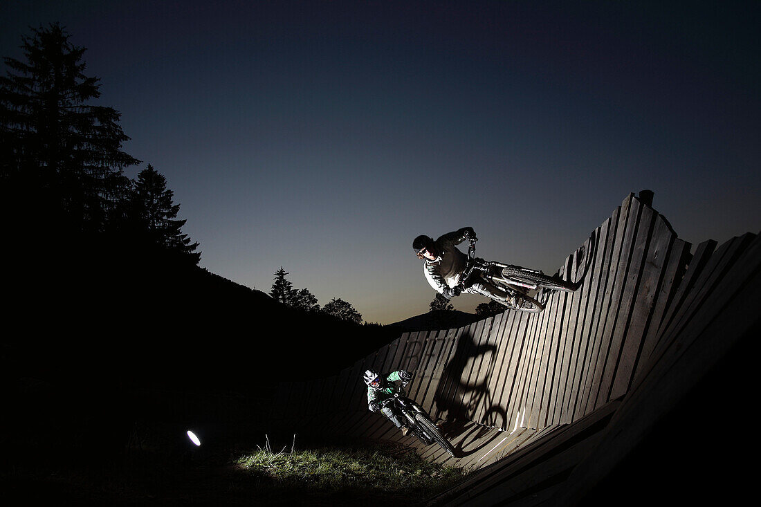 Two mountain bikers passing a wallride, Oberammergau, Bavaria, Germany