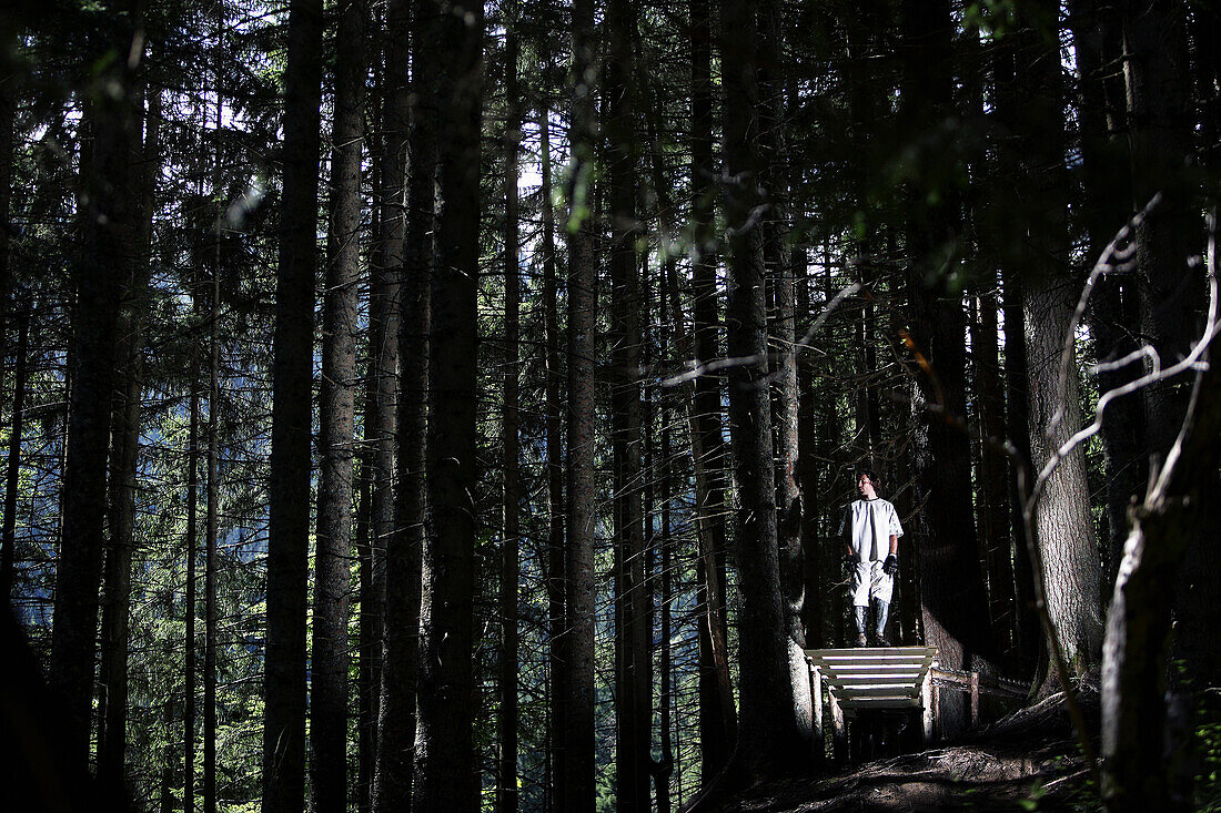 Junger Mann steht auf einer Rampe im Wald, Oberammergau, Bayern, Deutschland
