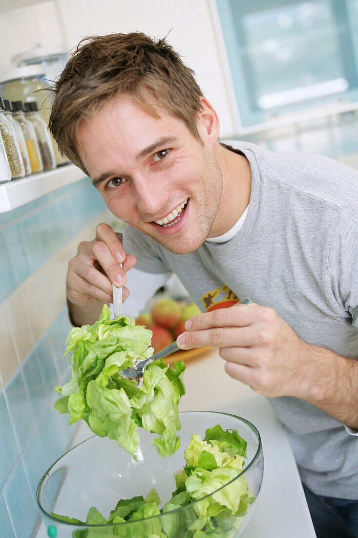Young man preparing a salad, Munich, Germany