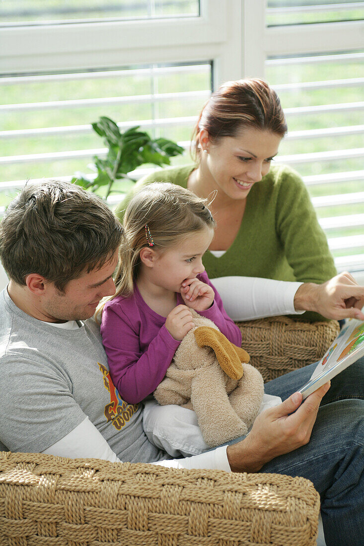 Family reading a book, Munich, Germany