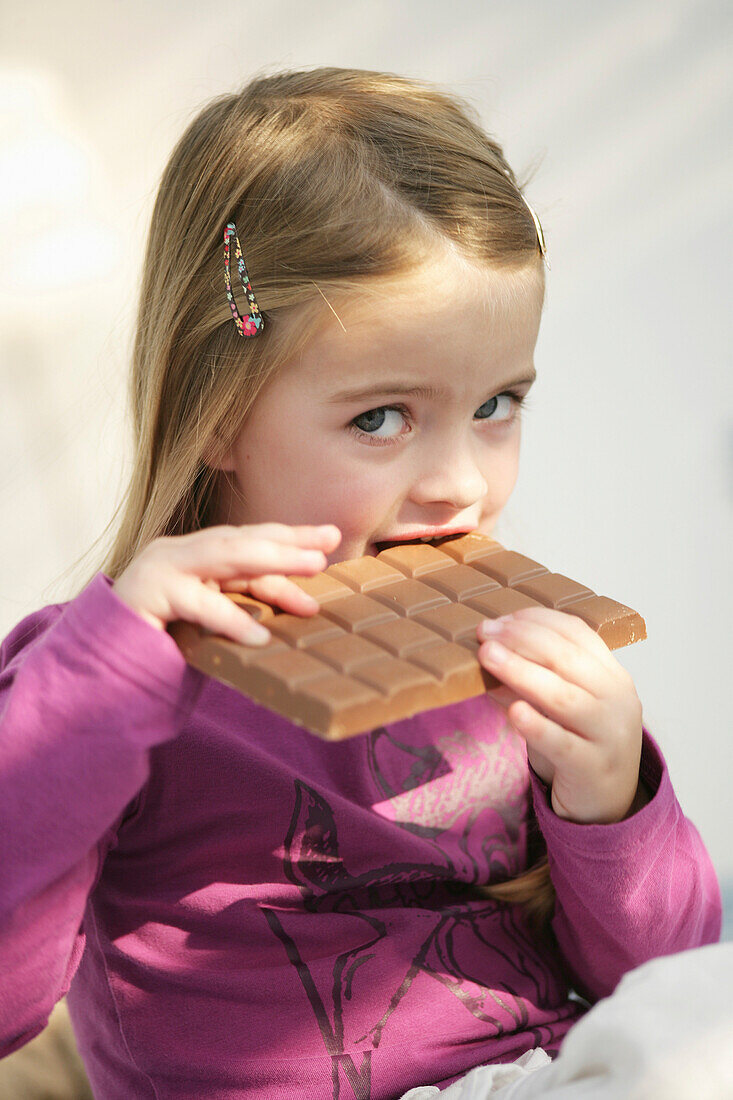 Mädchen (3-4 Jahre) isst Schokolade, München, Deutschland