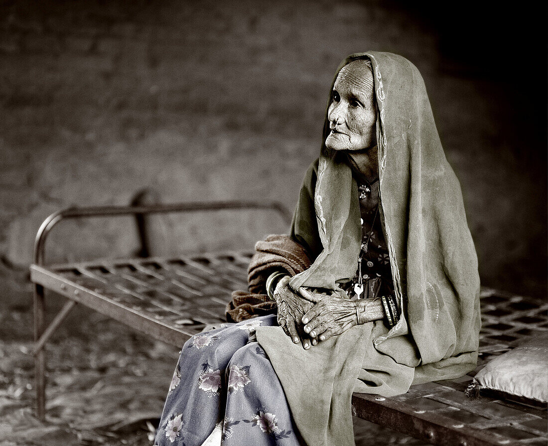Old lady in Rajasthan on bed. India