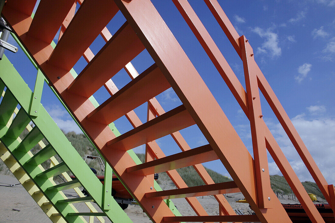 Colourful stairs on the beach with cloudy sky.