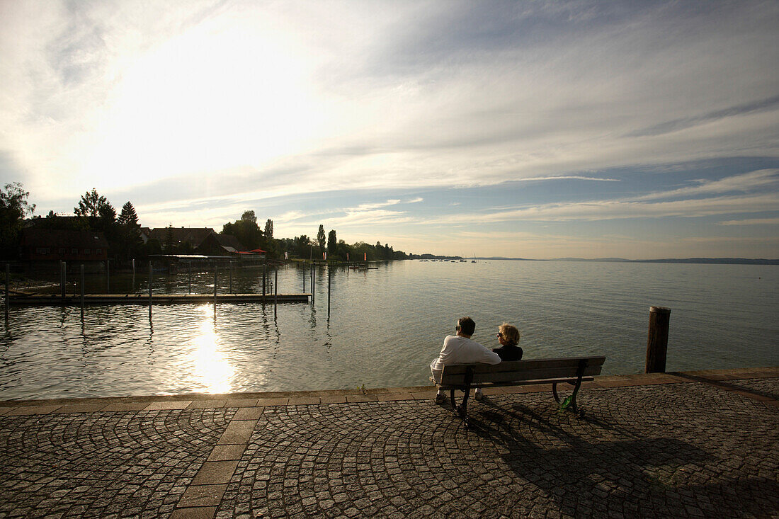 Couple resting on a bench at Lake Constance, Uttwil, Canton of Thurgau, Switzerland