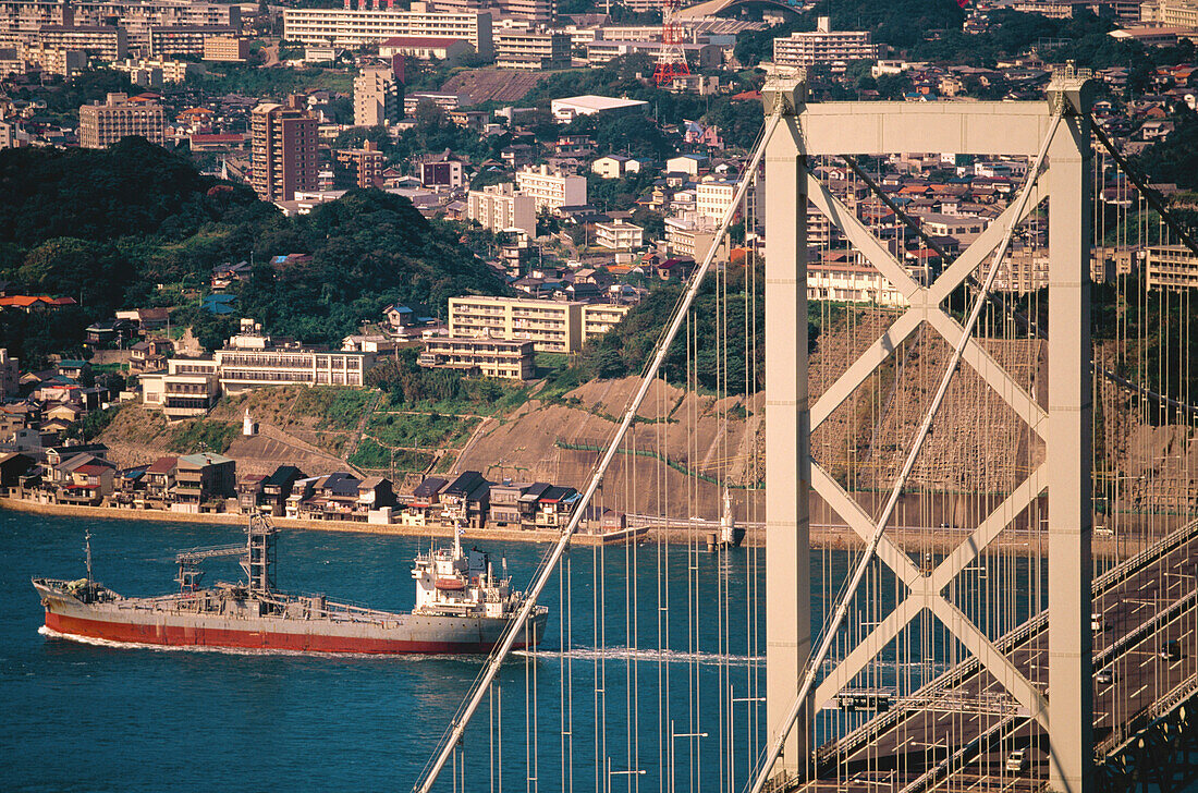 Freighter and Kanmon Bridge. Western Honshu. Japan