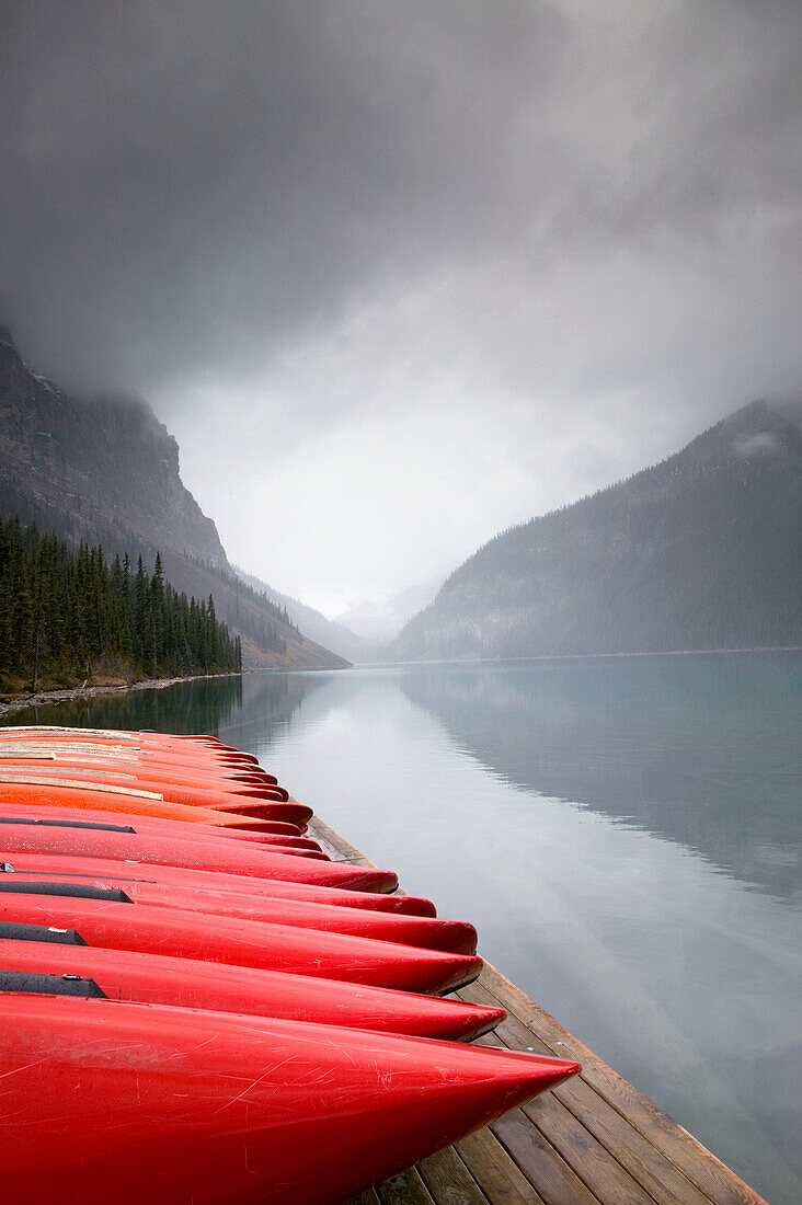 Red canoes and lake in early winter. Lake Louise, Banff National Park. Alberta, Canada