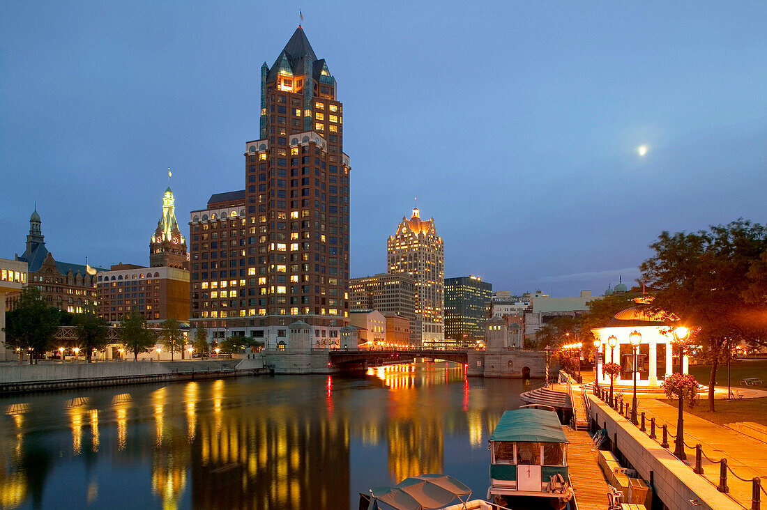 100 East Wisconsin Building and downtown from riverwalk of Milwaukee River at evening. Milwaukee. Wisconsin, USA
