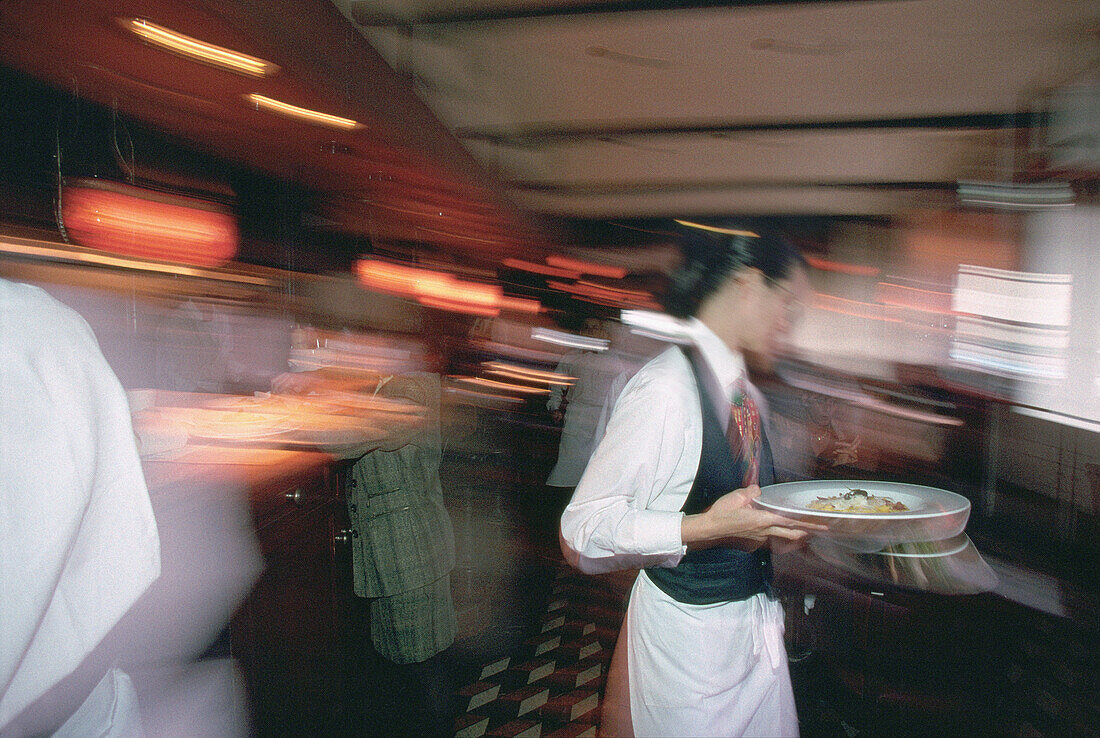 Blurred waiter with plates in a restaurant