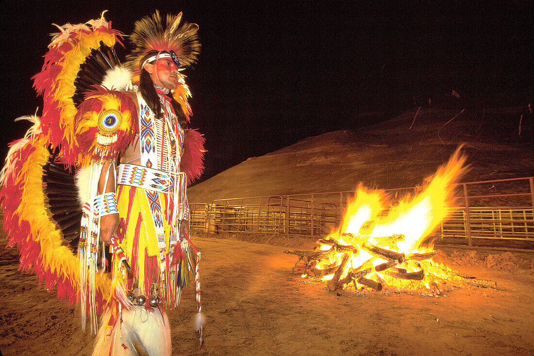 Bonfire and Kiowa Indian in fancy war dress. Indian ceremonial. Gallup. New Mexico. USA