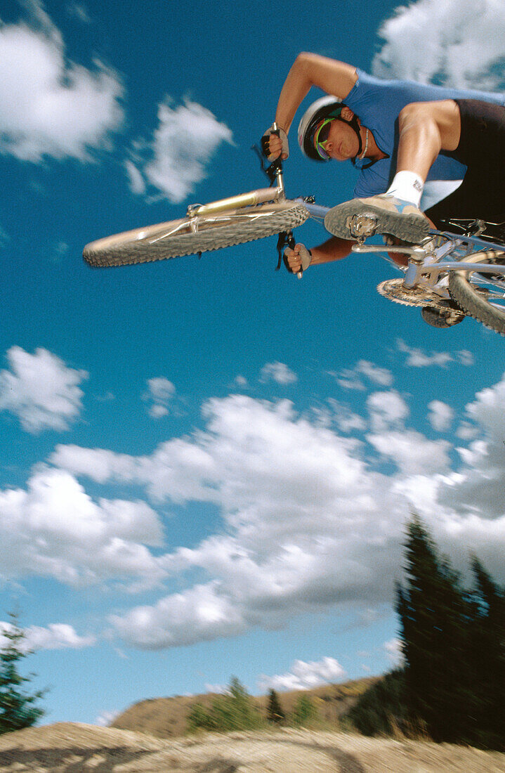 Aggressive mountain biker jumping into the sky