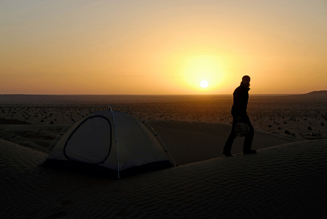 Sunset over the desert, a man walking up a sand dune, Sahara Desert Tour, Bebel Tembain area, Sahara, Tunisia, Africa, mr