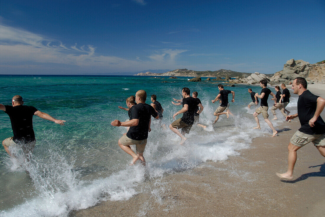 Eine Gruppe von Männer laufen ins Meer, Abenteuer Wettbewerb, in der Nähe von Rena Majore, Sardegna, Sardinien, Italien, Europa