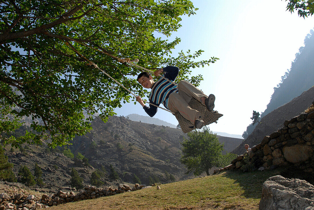 Junge auf eine Schaukel, Landschaft zwischen Kozluca und Tashan, Gebirgspass Divrik Dag, Highlands of Zamanti, Taurus Gebirge, Türkei, Europa