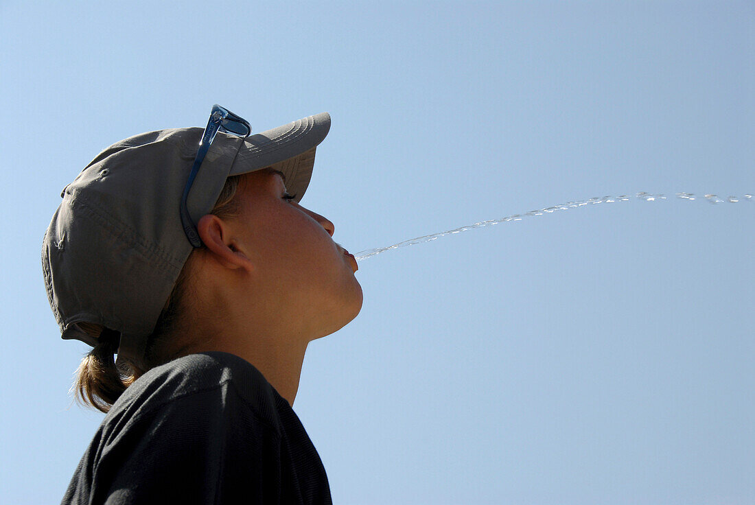 Young woman spitting water, Germany